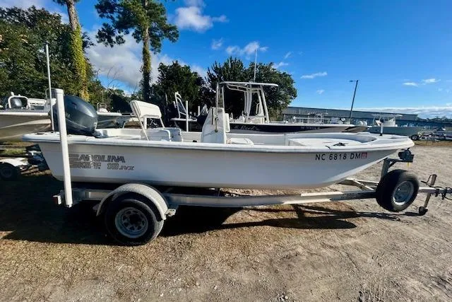 Slide: The Image of 2009 Carolina Skiff JVX18CC boat on trailer, parked outdoors under clear sky. - 0