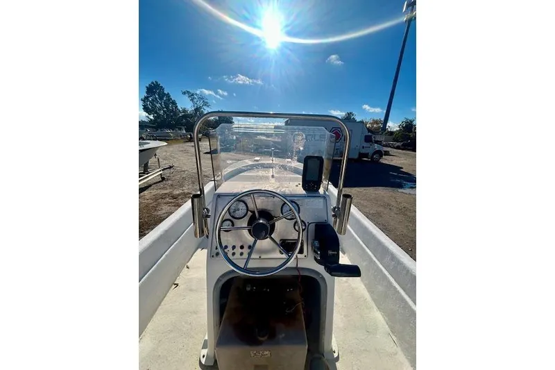 Slide: The Image of 2009 Carolina Skiff JVX18CC boat console under bright sun, showcasing steering wheel and controls. - 7