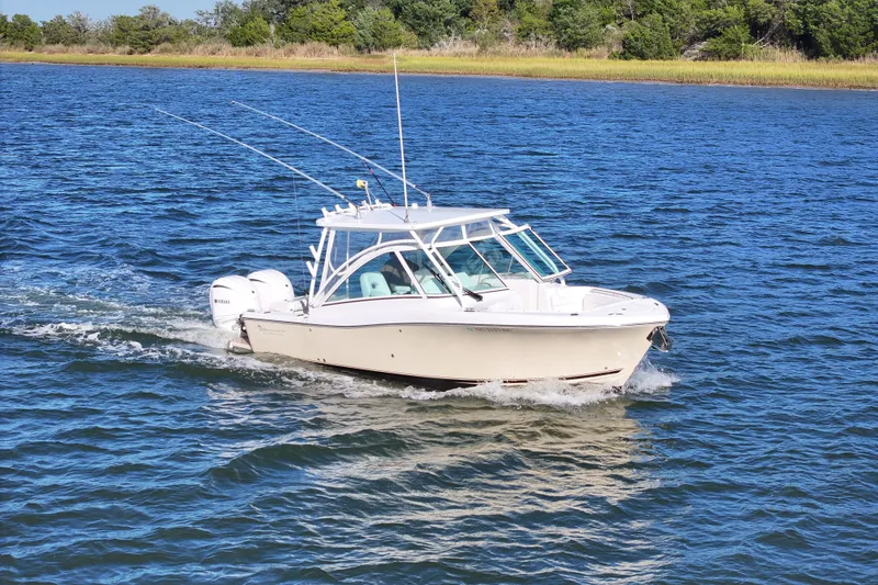 Slide: The Image of 2022 Albemarle 27 DC boat cruising on a scenic waterway with Seakeeper logo. - 1