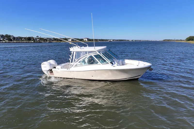 Slide: The Image of 2022 Albemarle 27 DC boat cruising on a serene blue lake. - 2