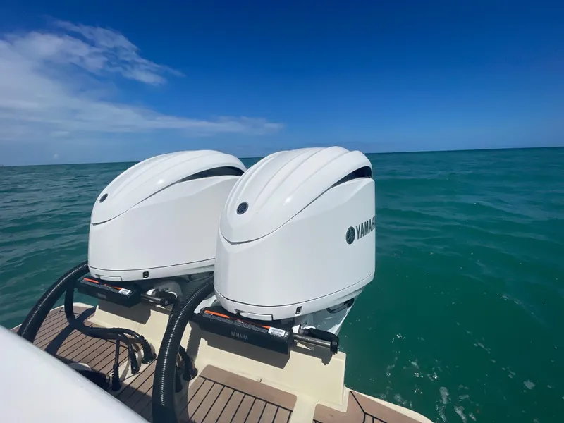 Slide: The Image of Twin Yamaha outboard engines on a 2022 Albemarle 27 DC boat, cruising in clear blue waters. - 23