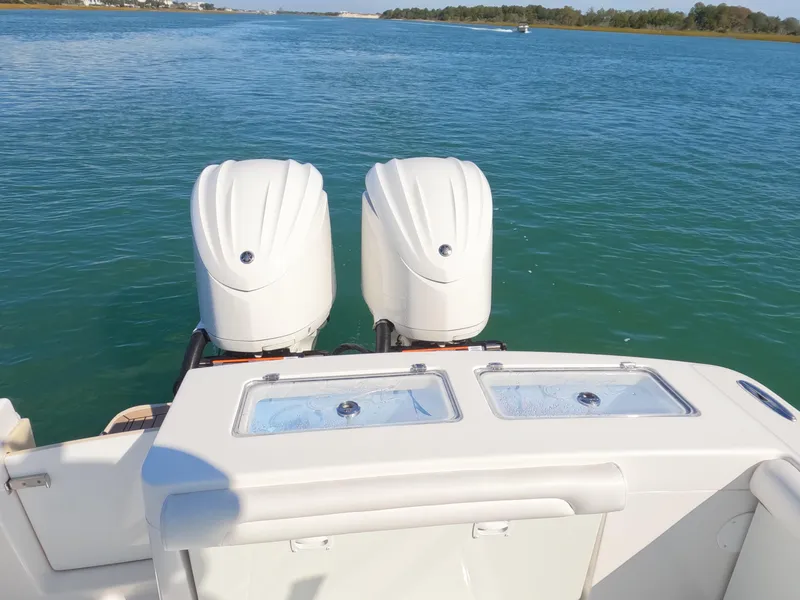 Slide: The Image of 2022 Albemarle 27 DC boat with dual outboard engines on a sunny day. - 28