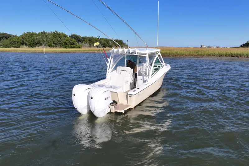Slide: The Image of 2022 Albemarle 27 DC boat cruising on a calm river under clear blue skies. - 3