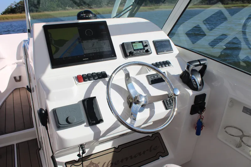 Slide: The Image of 2022 Albemarle 27 DC boat dashboard with steering wheel and navigation controls. - 36