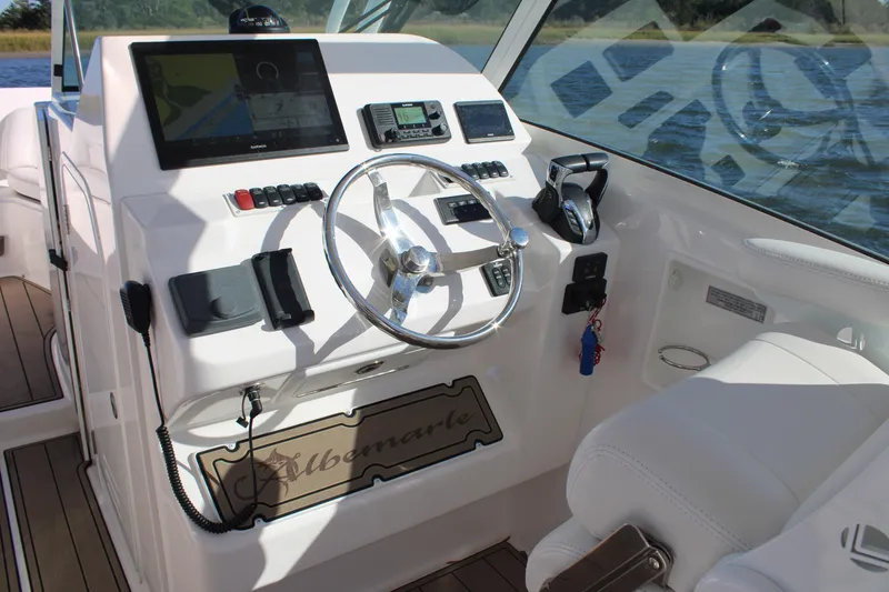 Slide: The Image of 2022 Albemarle 27 DC boat cockpit with steering wheel and navigation controls. - 37