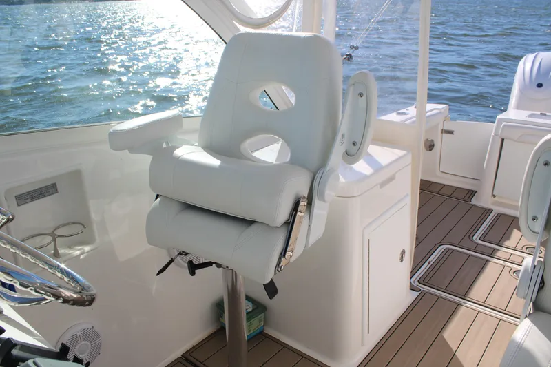Slide: The Image of Captain's chair on 2022 Albemarle 27 DC boat, overlooking water with sleek interior design. - 39