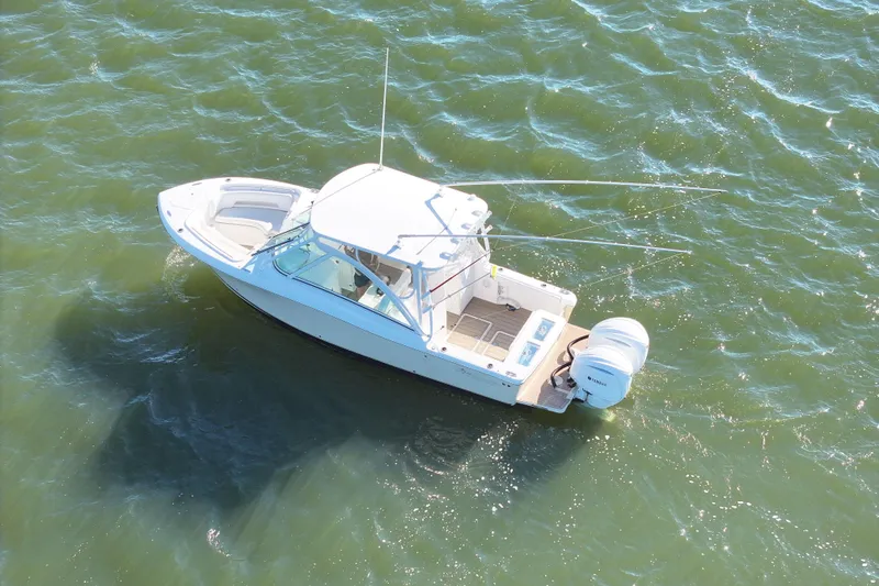 Slide: The Image of 2022 Albemarle 27 DC boat cruising on a sunny, sparkling waterway. - 6