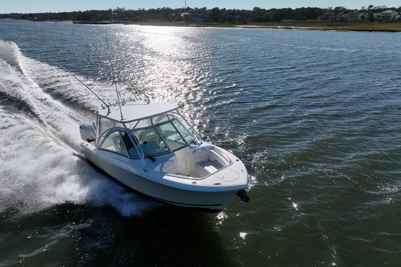 Slide: The Image of 2022 Albemarle 27 DC boat cruising on a sunny day near the shoreline. - 9