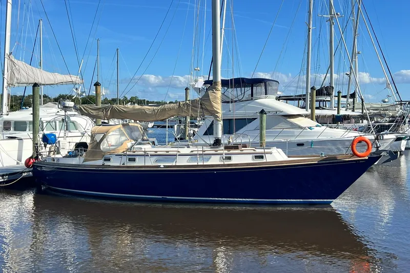 The Image of 1987 Bristol 41.1 Aft Cockpit sailboat docked in a marina, clear blue sky. - 0