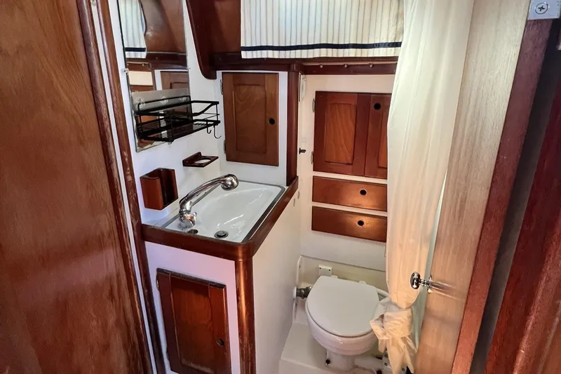 Slide: The Image of 1987 Bristol 41.1 Aft Cockpit yacht bathroom with wooden cabinetry and compact design. - 11