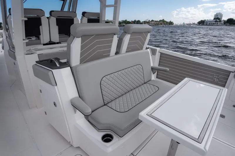 Slide: The Image of 2022 Pursuit S 428 Sport boat interior with luxurious seating and table by the water. - 15