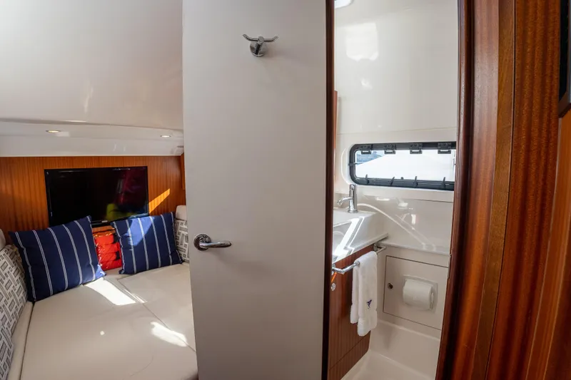 Slide: The Image of 2022 Pursuit S 428 Sport cabin interior with bed, pillows, and bathroom. - 31