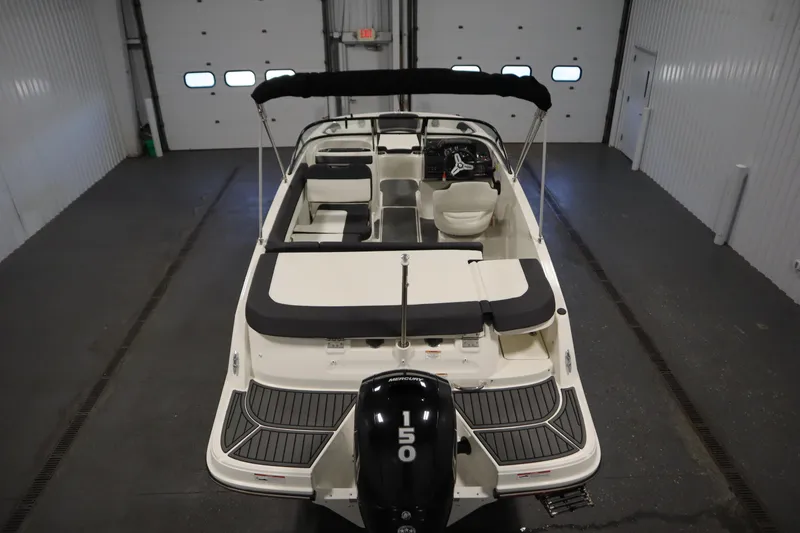 Slide: The Image of 2021 Bayliner VR5 Bowrider OB in a garage, showcasing seating and outboard motor. - 10