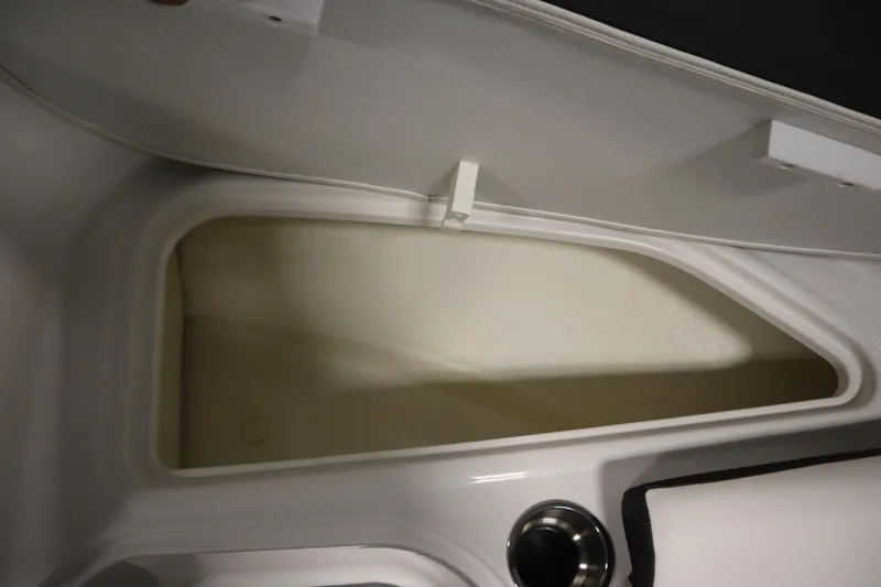Slide: The Image of 2021 Bayliner VR5 Bowrider OB storage compartment with open lid and cup holder. - 14