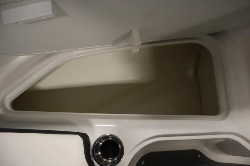 Slide: The Image of 2021 Bayliner VR5 Bowrider OB storage compartment with cup holder, open lid view. - 16