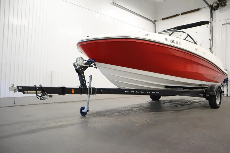 Slide: The Image of 2021 Bayliner VR5 Bowrider OB, red and white, on trailer in indoor setting. - 49