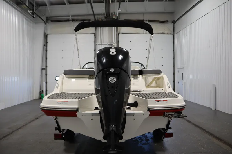 Slide: The Image of 2021 Bayliner VR5 Bowrider OB in a garage, rear view with outboard motor. - 6