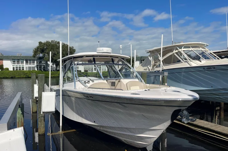 Slide: The Image of 2011 Grady-White Freedom 307 boat docked at marina under blue sky. - 1