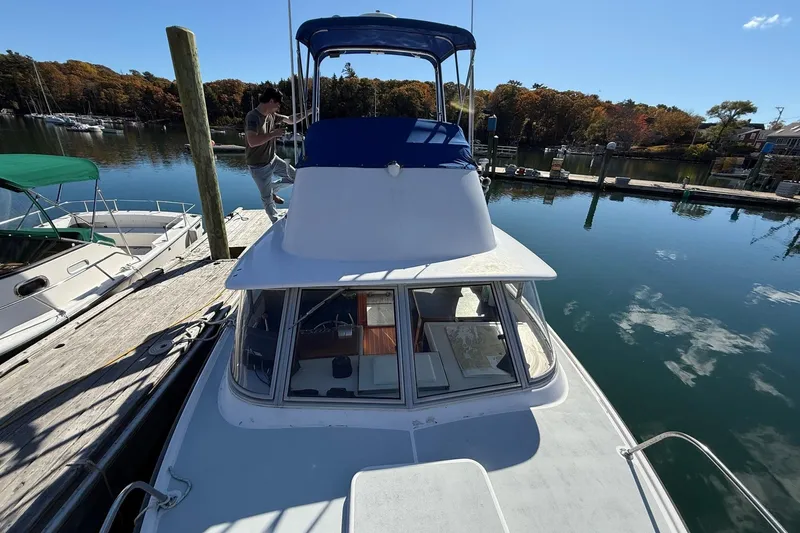 Slide: The Image of 1963 Bertram 31 Flybridge Cruiser docked at a serene marina. - 14
