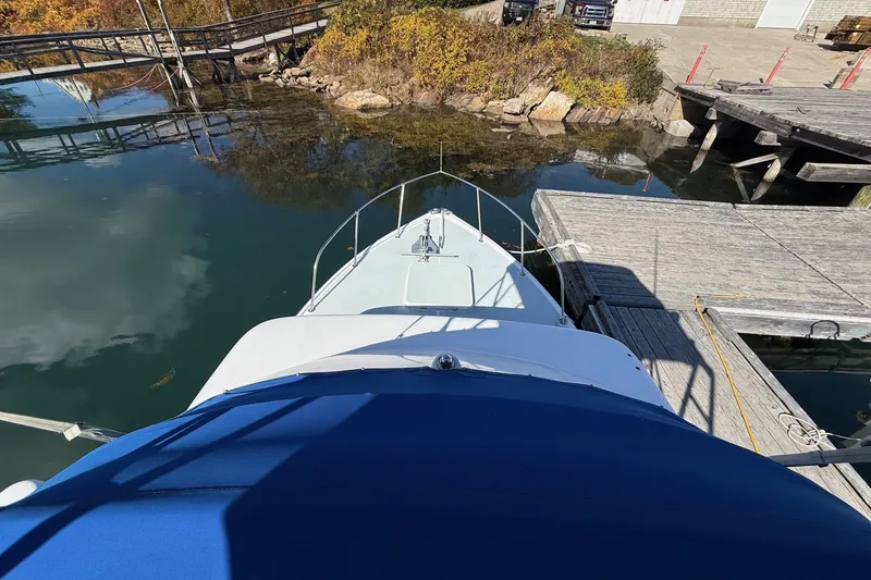 Slide: The Image of 1963 Bertram 31 Flybridge Cruiser docked at a serene marina. - 15