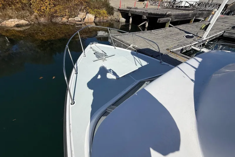 Slide: The Image of 1963 Bertram 31 Flybridge Cruiser docked, showing bow and shadow on deck. - 17
