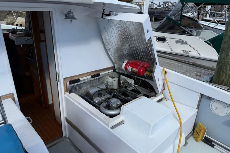 Slide: The Image of 1963 Bertram 31 Flybridge Cruiser engine compartment with fire extinguisher, docked at marina. - 22