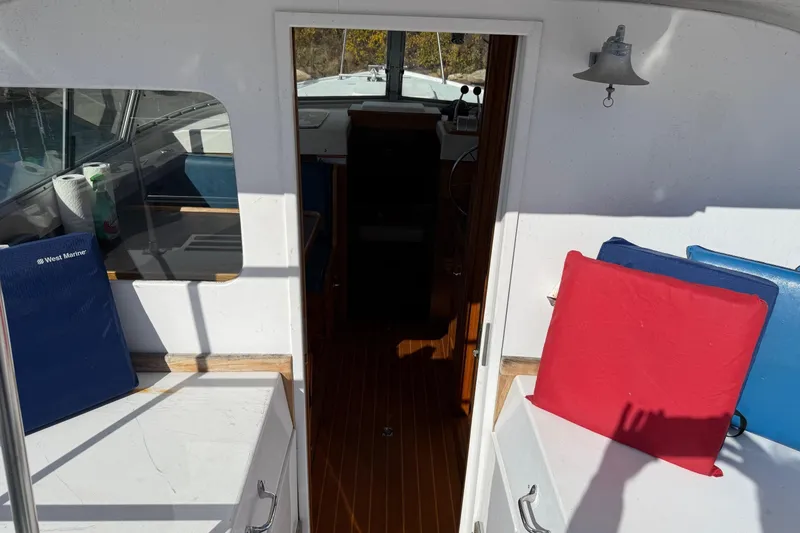 Slide: The Image of Interior view of a 1963 Bertram 31 Flybridge Cruiser with colorful cushions and wooden flooring. - 30