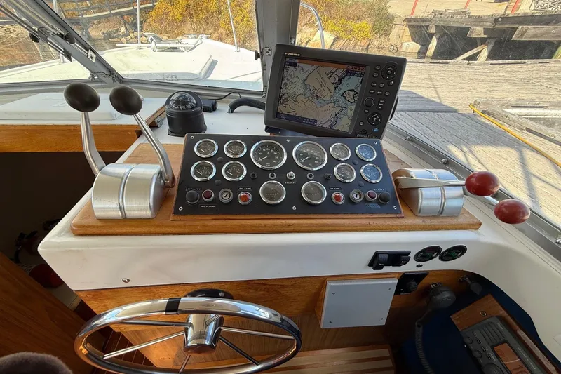 Slide: The Image of 1963 Bertram 31 Flybridge Cruiser helm with gauges, controls, and navigation system. - 33