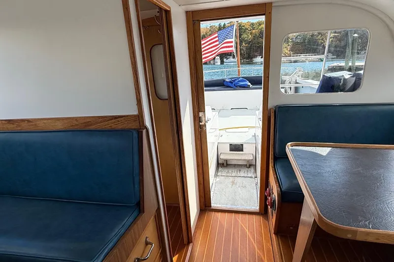 Slide: The Image of Interior of a 1963 Bertram 31 Flybridge Cruiser with blue seating and wooden accents. - 37
