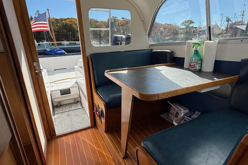 Slide: The Image of Interior of a 1963 Bertram 31 Flybridge Cruiser with dining area and American flag view. - 40