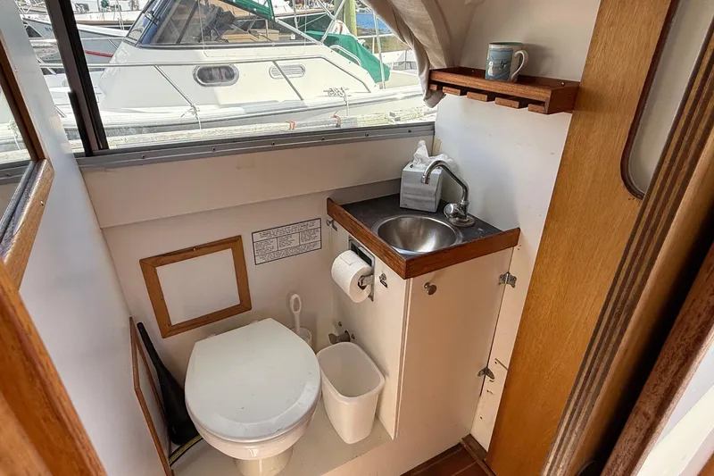 Slide: The Image of Compact bathroom in a 1963 Bertram 31 Flybridge Cruiser with sink and toilet. - 46