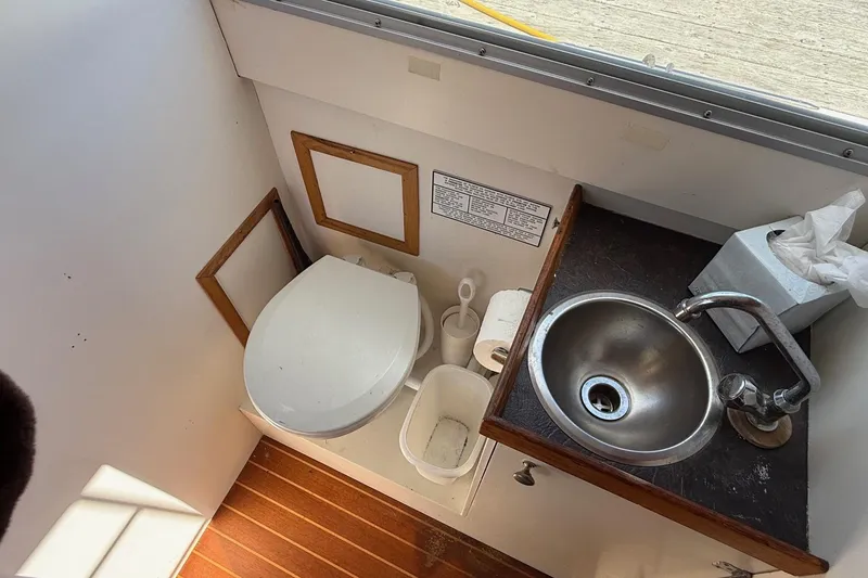 Slide: The Image of Compact bathroom in a 1963 Bertram 31 Flybridge Cruiser with toilet and sink. - 47