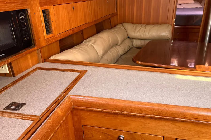 Slide: The Image of Interior of 2002 Hunter 460 yacht with wood cabinetry and beige seating area. - 4