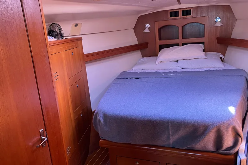 Slide: The Image of Cozy cabin interior of 2002 Hunter 460 sailboat with wooden furnishings and comfortable bedding. - 8