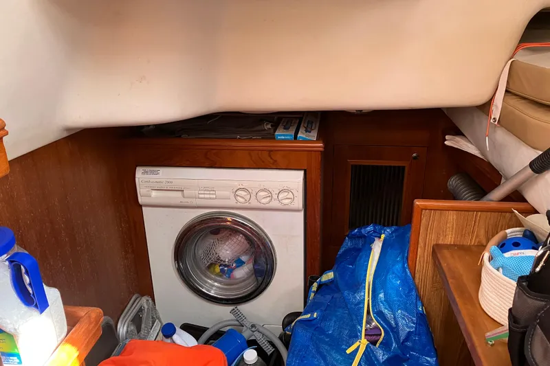 Slide: The Image of Laundry area inside a 2002 Hunter 460 yacht with washing machine and storage items. - 9