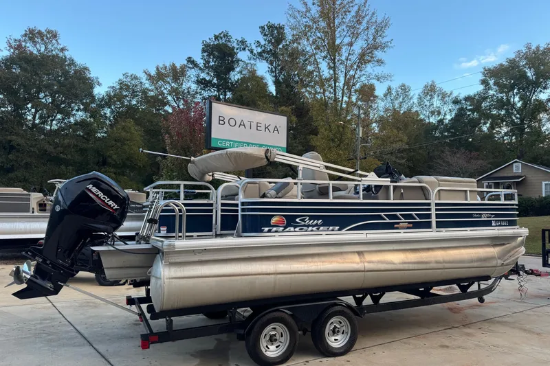 Slide: The Image of 2023 Sun Tracker Fishin' Barge 20 DLX pontoon boat on trailer at dealership. - 2