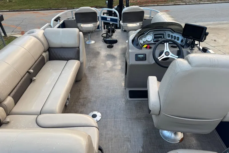 Slide: The Image of 2023 Sun Tracker Fishin' Barge 20 DLX interior with beige seating and modern dashboard. - 3