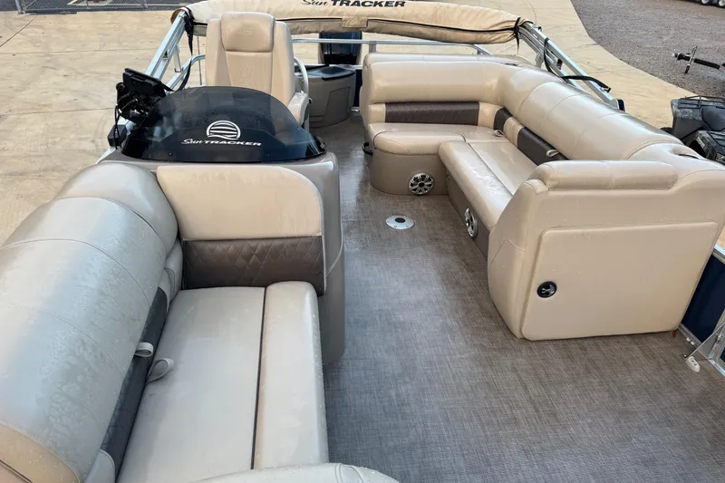 Slide: The Image of 2023 Sun Tracker Fishin' Barge 20 DLX interior with beige seating and helm. - 5
