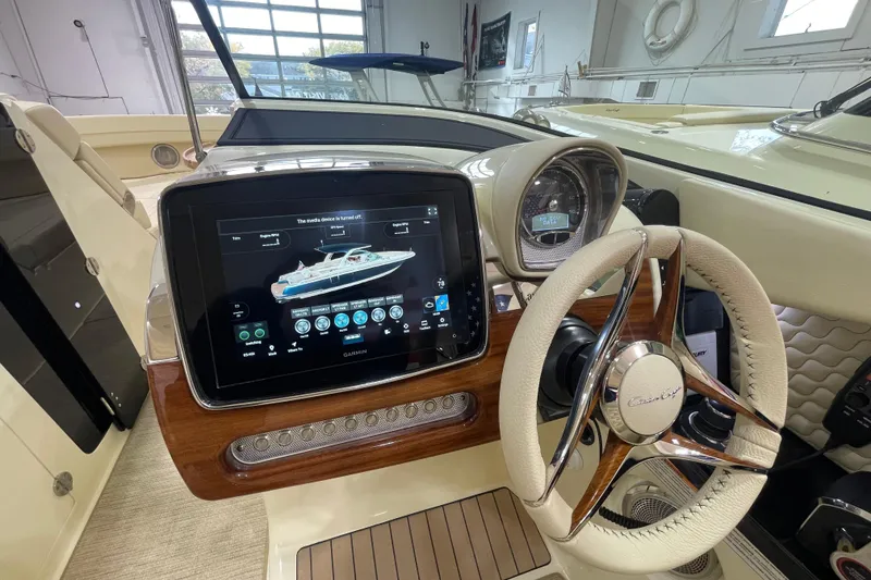 Slide: The Image of 2026 Chris-Craft Launch 31 GT dashboard with touchscreen and steering wheel in luxury boat interior. - 30
