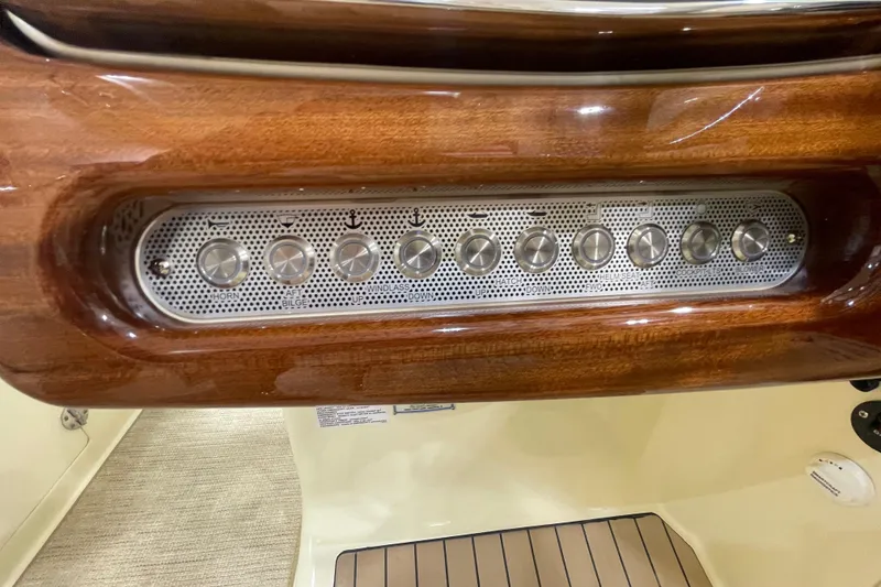 Slide: The Image of Control panel of 2026 Chris-Craft Launch 31 GT with wooden finish and metallic buttons. - 38