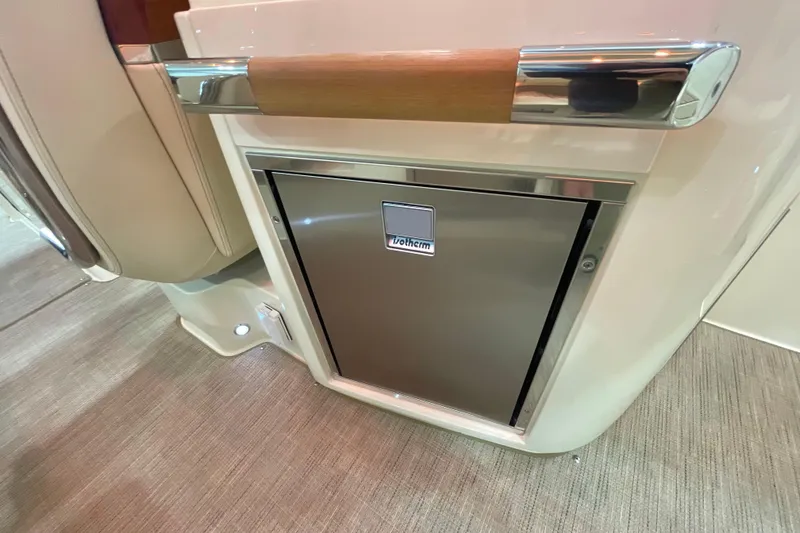 Slide: The Image of 2026 Chris-Craft Launch 31 GT interior with built-in refrigerator and elegant wood accents. - 56
