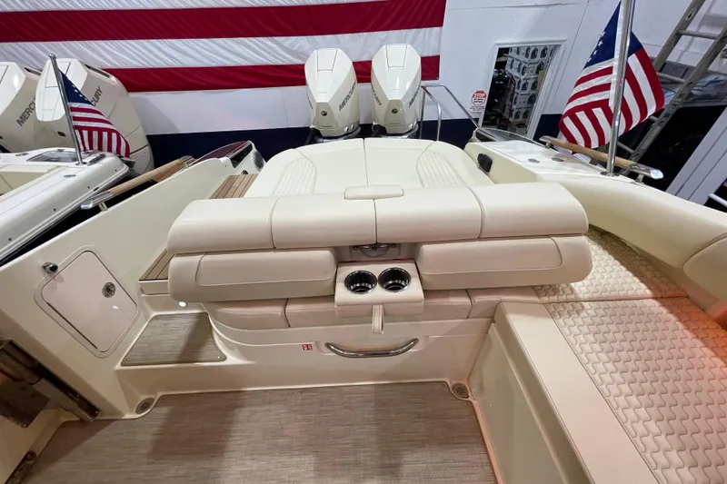 Slide: The Image of 2026 Chris-Craft Launch 31 GT boat interior with beige seating and American flag. - 65
