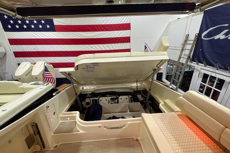 Slide: The Image of 2026 Chris-Craft Launch 31 GT boat interior with open engine compartment, American flag backdrop. - 71