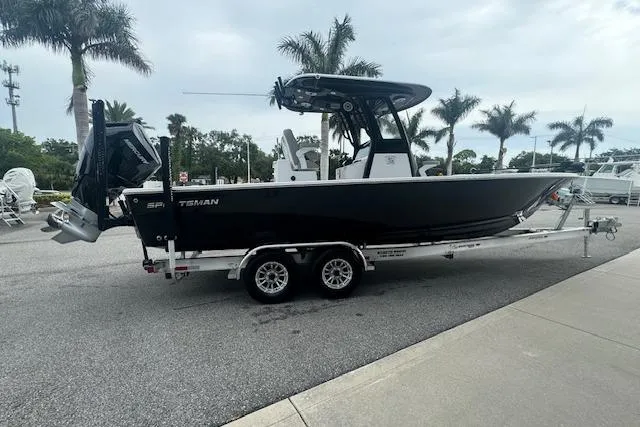Slide: The Image of 2025 Sportsman Masters 267OE Bay Boat on trailer, parked near palm trees. - 16