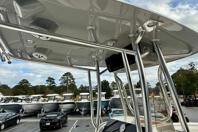 Slide: The Image of 2026 Bulls Bay 230 Center Console boat with T-top and speakers, parked in a marina. - 12