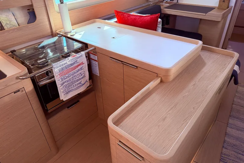 Slide: The Image of Modern kitchen interior of 2022 Beneteau Oceanis Yacht 54 with wooden cabinetry and stove. - 33