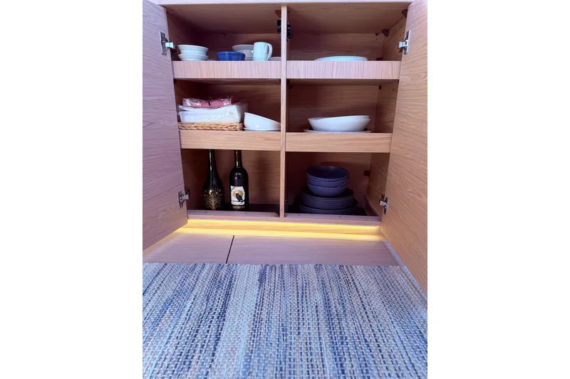 Slide: The Image of Cabinet interior with dishes and wine bottles on Beneteau Oceanis Yacht 54, 2022 model. - 36