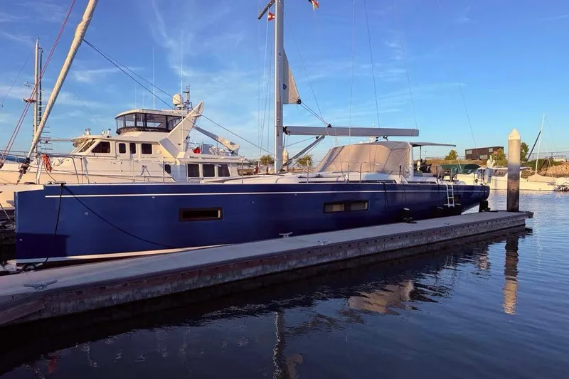 Slide: The Image of 2022 Beneteau Oceanis Yacht 54 docked at marina, blue hull, clear sky. - 4