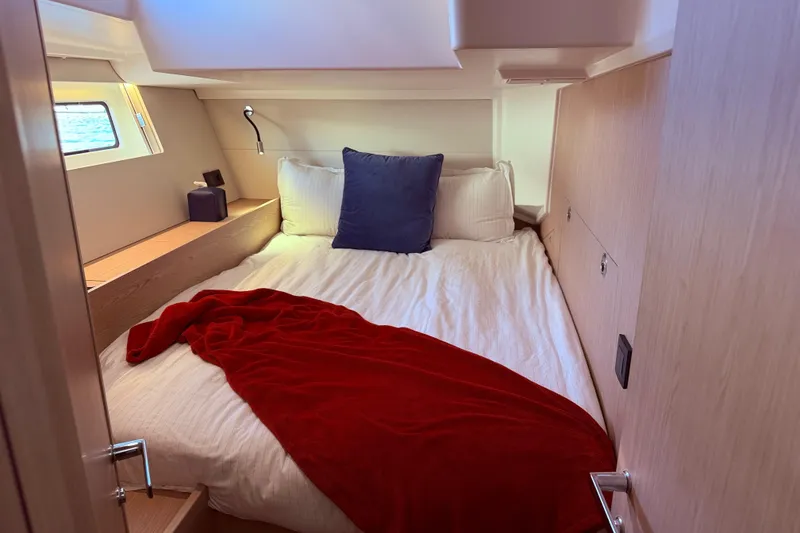 Slide: The Image of Cozy cabin interior of 2022 Beneteau Oceanis Yacht 54 with bed and red blanket. - 40