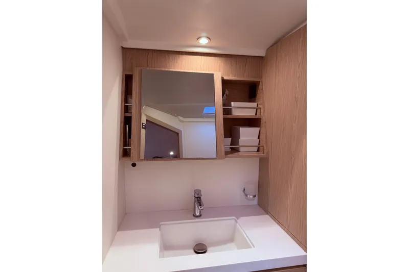 Slide: The Image of Modern bathroom vanity in 2022 Beneteau Oceanis Yacht 54, featuring sleek sink and wooden cabinetry. - 44